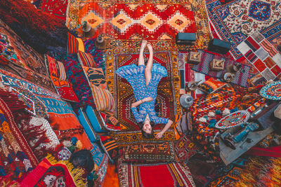 Portrait of woman lying on carpet in store