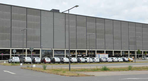 Cars on road by building against sky