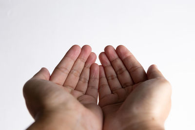 Close-up of hands over white background