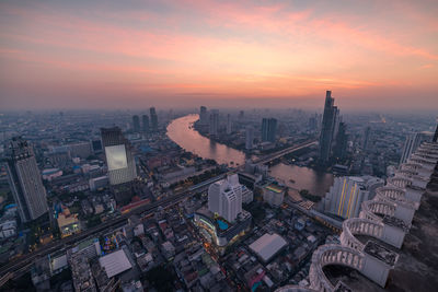 High angle view of modern buildings in city against sky during sunset