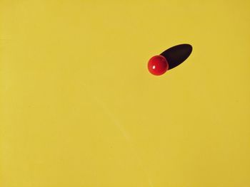 Close-up of red balloons against yellow wall