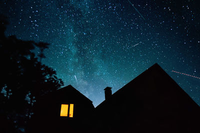 Low angle view of silhouette building against sky at night