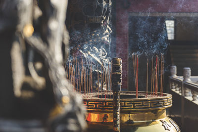 Incense sticks burning in container at temple