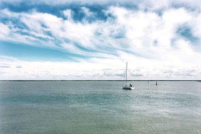 Sailboat sailing on sea against sky