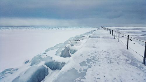 Scenic view of snow covered sea against sky