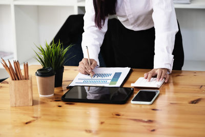 Midsection of woman sitting at table