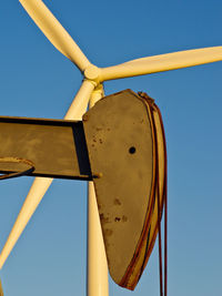 Low angle view of windmill against clear blue sky