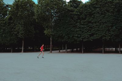 Man playing on field against trees