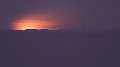 Silhouette landscape against clear sky during sunset
