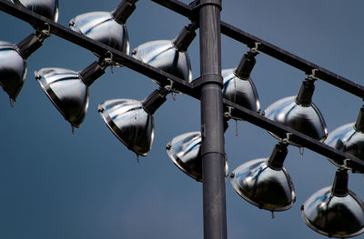 Low angle view of spotlights against clear blue sky