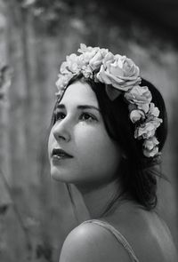 Close-up of beautiful woman looking up while wearing rose wreath