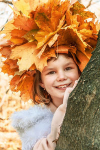 Portrait of a smiling girl in autumn leaves