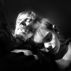 Close-up of grandfather and grandson sleeping in darkroom