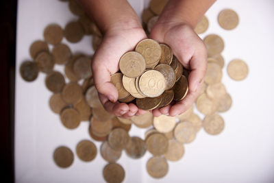 High angle view of hand holding coins