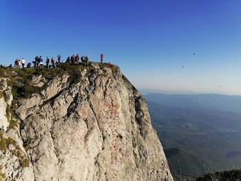 Scenic view of mountains against clear sky with group of people