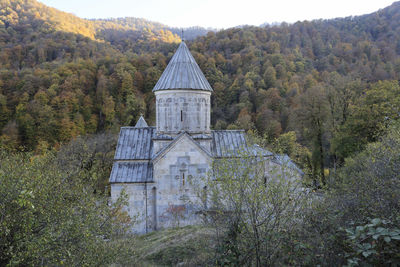 Built structure by trees and mountains in forest