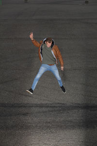 Full length of young man jumping over road