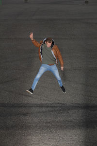 Full length of young man jumping over road