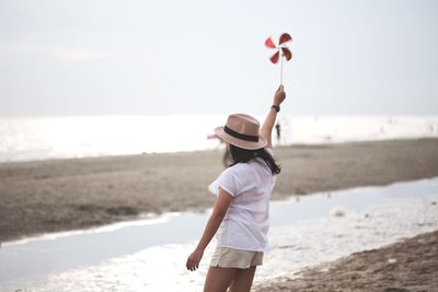 Woman standing on beach against sea