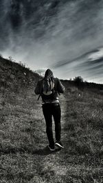 Full length rear view of man walking on grass