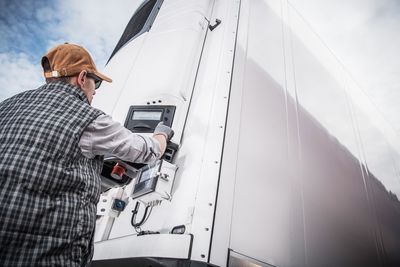 Man touching refrigerated trailer cargo