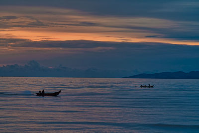 Silhouette boat in sea against sky during sunset