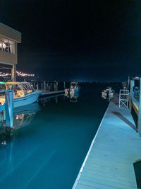 Swimming pool by sea against sky at night