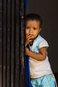 A child looking towards the camera and thinking.