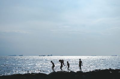 Four children walking on coastline