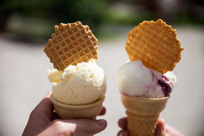 Cropped hands holding ice cream cones