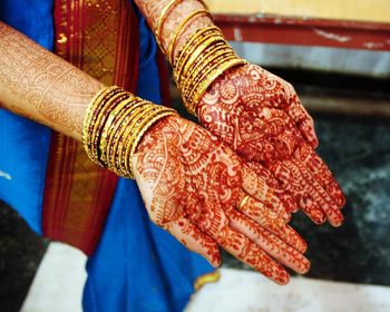 Midsection of bride wearing sari with heena tattoo