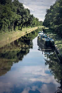 Scenic view of barge on canal against sky