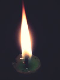 Close-up of lit candle in dark room