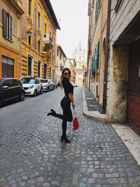 Full length of woman on street amidst buildings in city