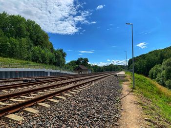 Railroad tracks by trees against sky