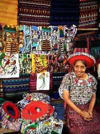 Full length portrait of smiling woman for sale in market