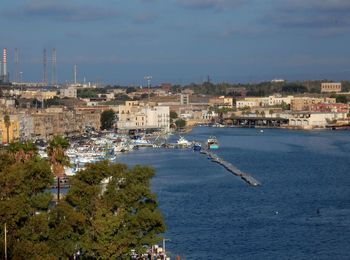 Scenic view of sea by buildings against sky