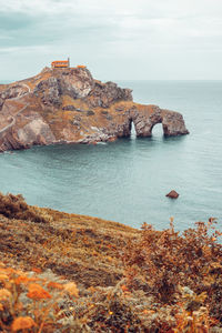 Rock formations on shore against sky