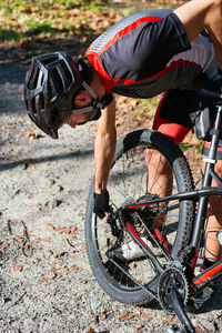 Man holding bicycle wheel outdoors