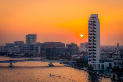 Modern buildings against sky during sunset