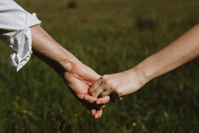 Midsection of couple holding hands