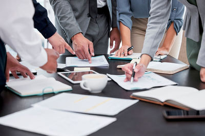 Midsection of business colleagues working on table