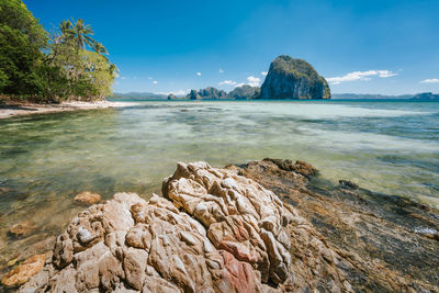 Scenic view of rocks in sea against blue sky