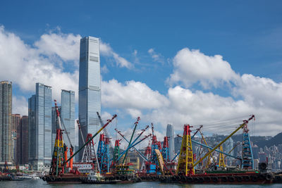 Cranes at harbor against sky