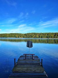 Pier over lake against blue sky