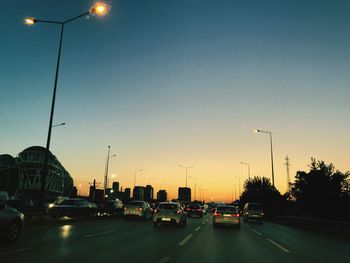 Traffic on road at sunset