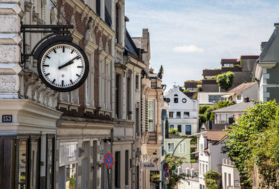 Low angle view of clock tower amidst buildings in city