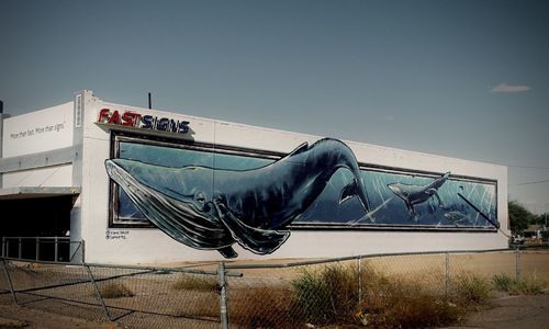 Clothes drying against building against clear blue sky