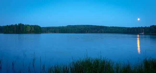 Scenic view of lake against clear blue sky