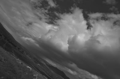 Low angle view of storm clouds over mountain